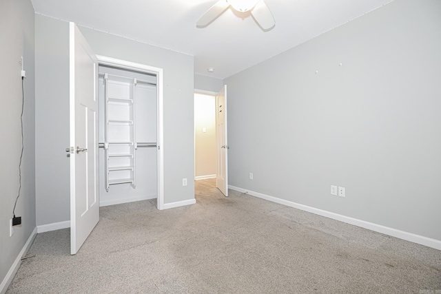 unfurnished bedroom featuring light carpet, ceiling fan, and a closet