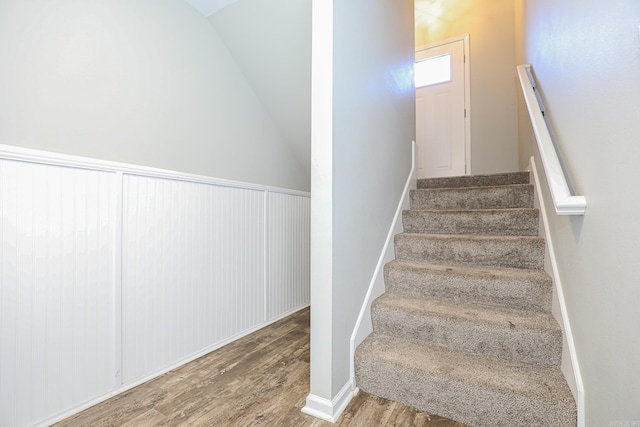 stairway with lofted ceiling and hardwood / wood-style flooring