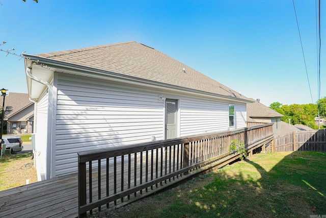 rear view of property with a wooden deck and a yard