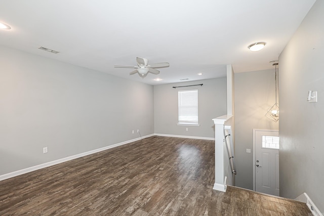 empty room with ceiling fan, plenty of natural light, and dark wood-type flooring