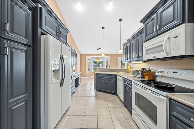 kitchen with appliances with stainless steel finishes, gray cabinetry, light tile patterned floors, lofted ceiling, and decorative light fixtures