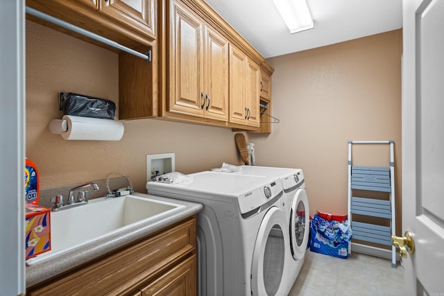 washroom with washing machine and dryer, light tile patterned flooring, sink, and cabinets