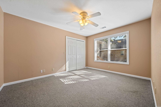 unfurnished bedroom with a closet, ceiling fan, and carpet floors