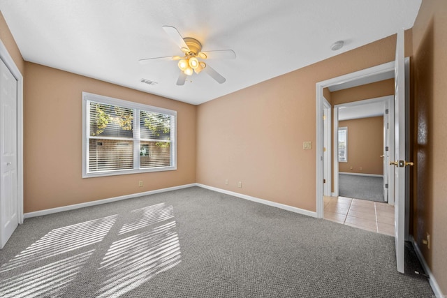 unfurnished bedroom with ceiling fan, a closet, and light carpet