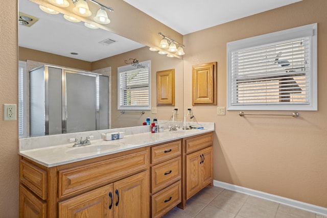 bathroom featuring vanity, a shower with shower door, and tile patterned floors