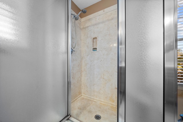 bathroom with a shower with door