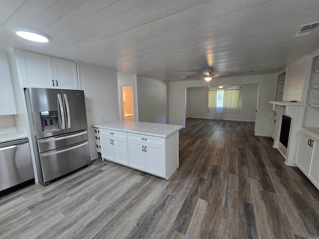 kitchen featuring white cabinetry, kitchen peninsula, stainless steel appliances, ceiling fan, and hardwood / wood-style flooring