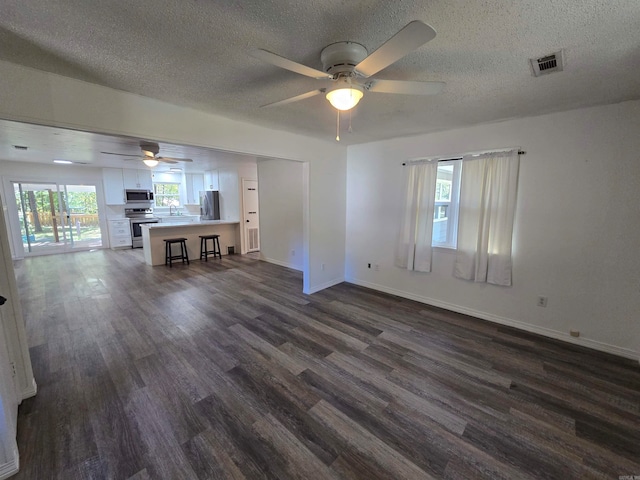 unfurnished living room featuring ceiling fan, a textured ceiling, sink, and dark hardwood / wood-style flooring