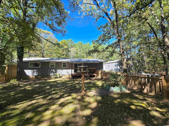 rear view of property featuring a lawn and a wooden deck