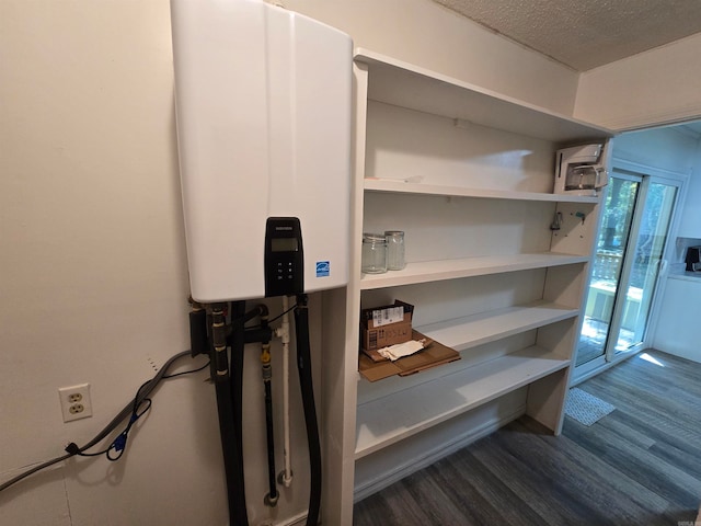 interior details featuring wood-type flooring, a textured ceiling, and tankless water heater