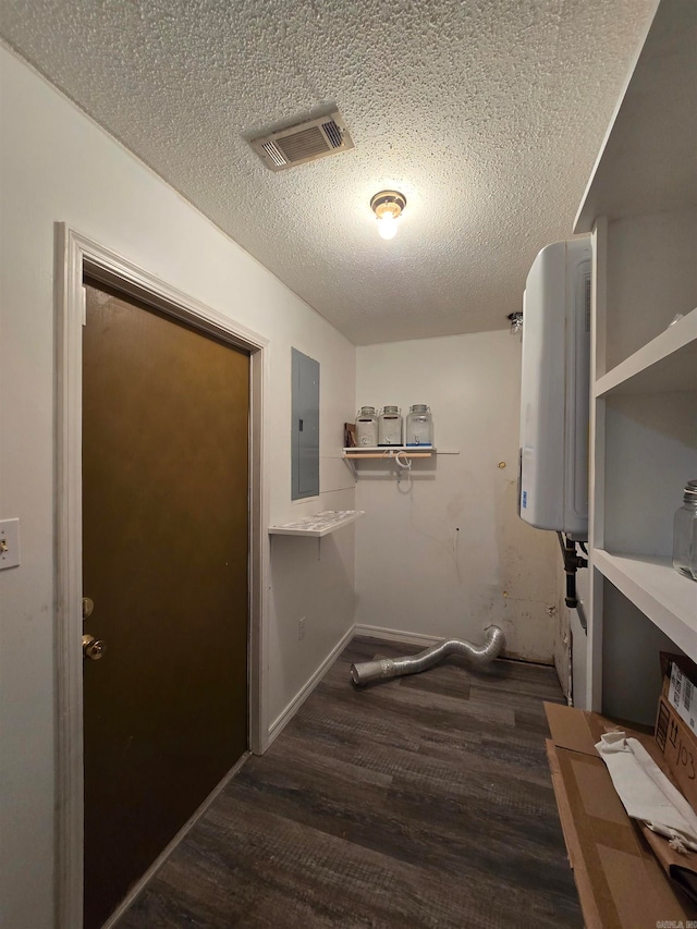 clothes washing area with dark hardwood / wood-style floors, a textured ceiling, and electric panel