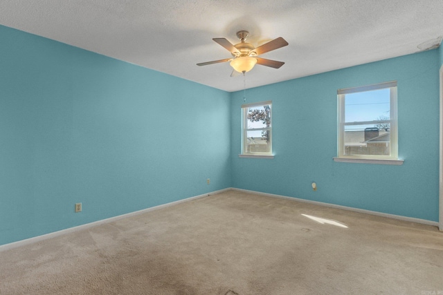 unfurnished room with a textured ceiling, carpet floors, and ceiling fan