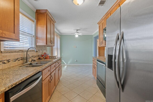 kitchen with light stone countertops, sink, tasteful backsplash, appliances with stainless steel finishes, and ornamental molding