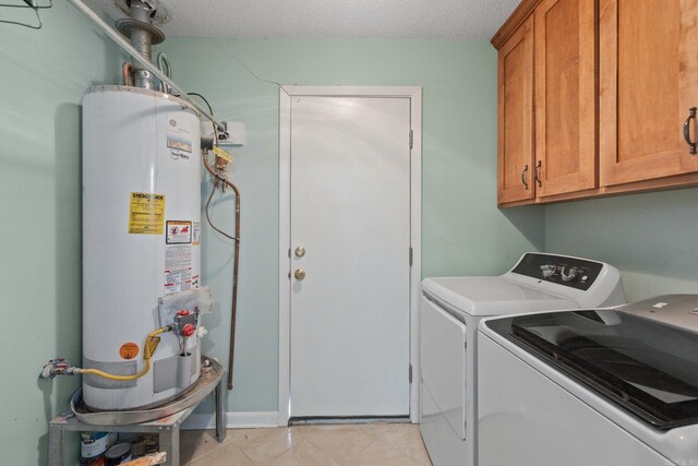 laundry room with cabinets, a textured ceiling, separate washer and dryer, and water heater