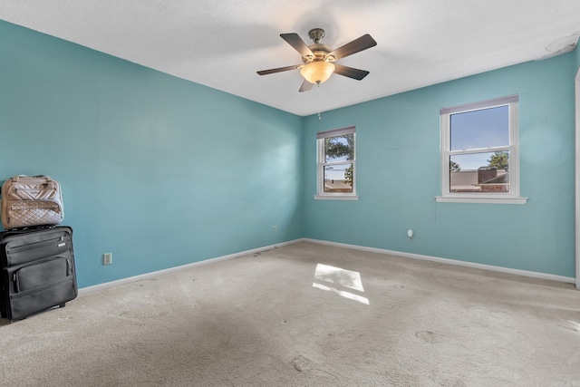 carpeted spare room featuring ceiling fan and a textured ceiling