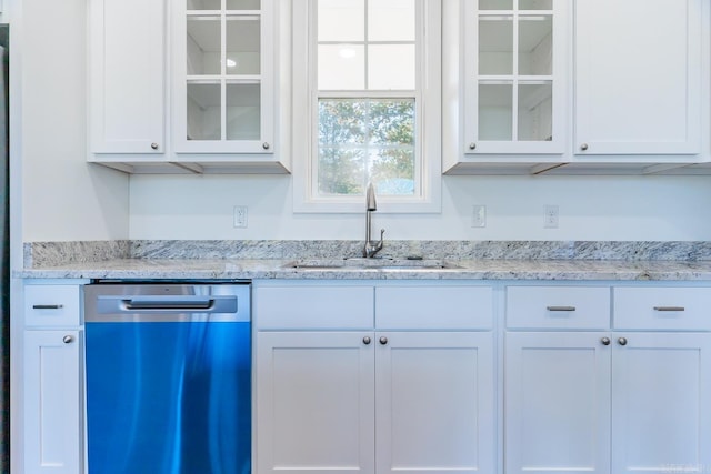 kitchen with white cabinets, dishwasher, light stone counters, and sink