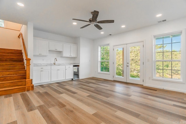 kitchen with light hardwood / wood-style floors, sink, white cabinetry, ceiling fan, and french doors