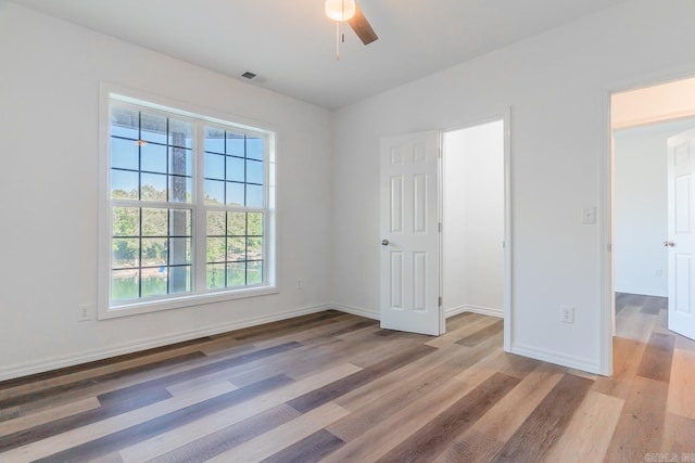 empty room with ceiling fan and hardwood / wood-style flooring