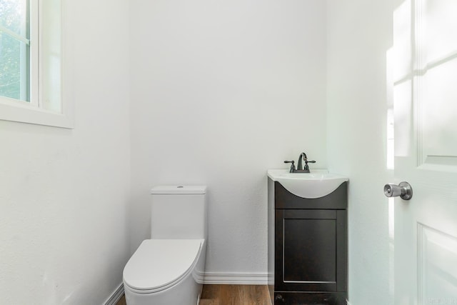 bathroom featuring wood-type flooring, vanity, and toilet