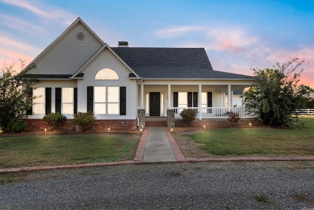 view of front of house with a yard and a porch