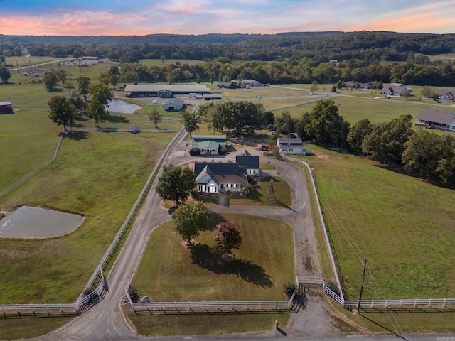 aerial view at dusk with a water view and a rural view