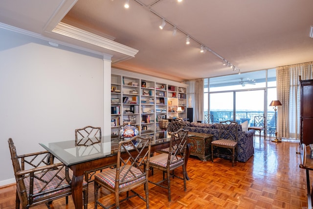 dining space featuring track lighting, light parquet floors, floor to ceiling windows, and ornamental molding