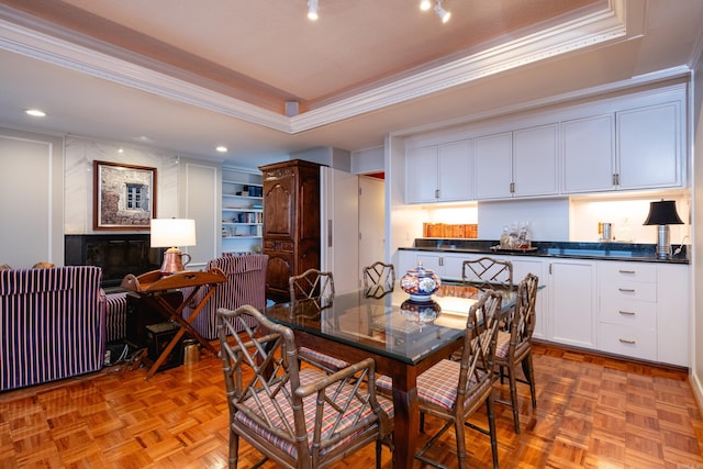 dining area with a raised ceiling, ornamental molding, light parquet floors, and radiator heating unit