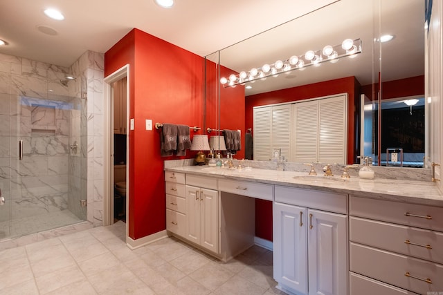 bathroom featuring a shower with shower door, vanity, and toilet