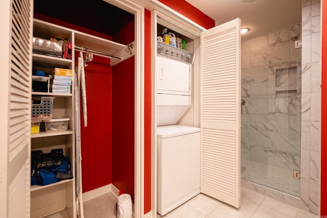 laundry area with light tile patterned flooring and stacked washing maching and dryer