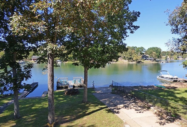 dock area with a water view and a lawn