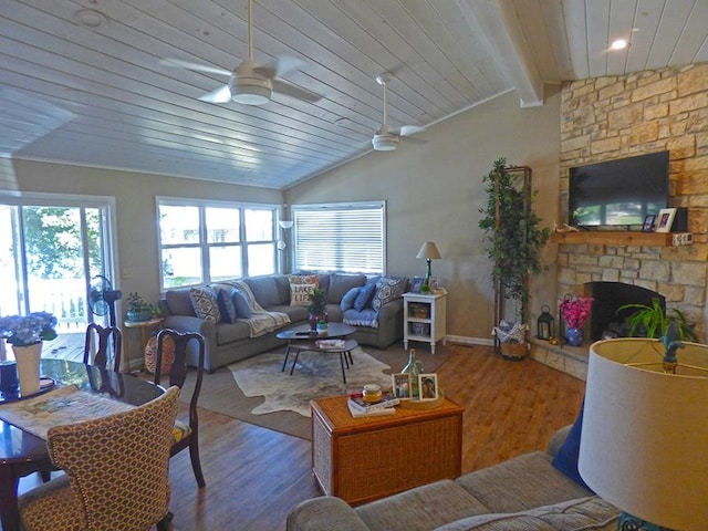 living room featuring lofted ceiling with beams, wood ceiling, a stone fireplace, and wood-type flooring