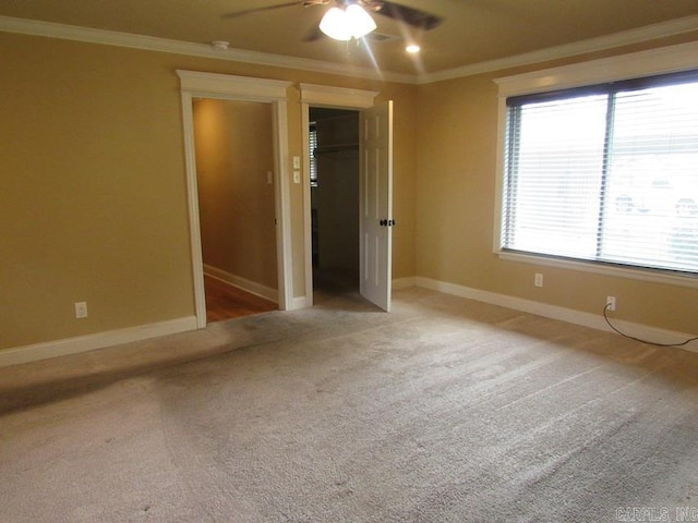 carpeted empty room with ornamental molding and ceiling fan