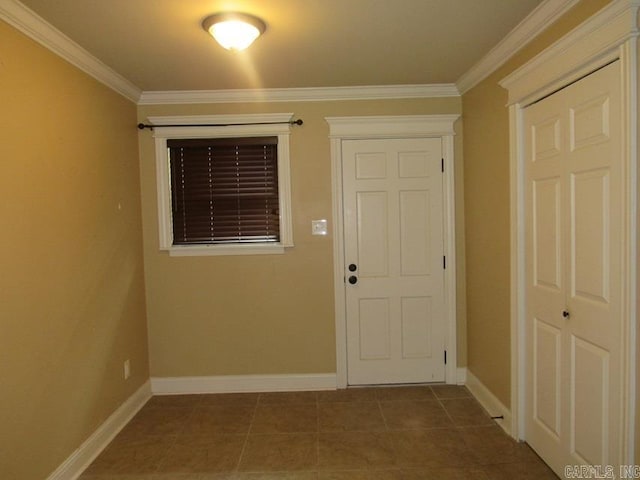 entryway with ornamental molding and dark tile patterned flooring