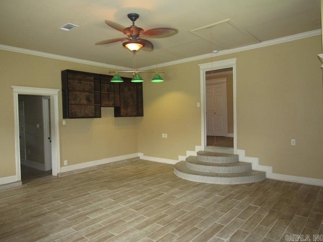 spare room with ornamental molding, light wood-type flooring, and ceiling fan