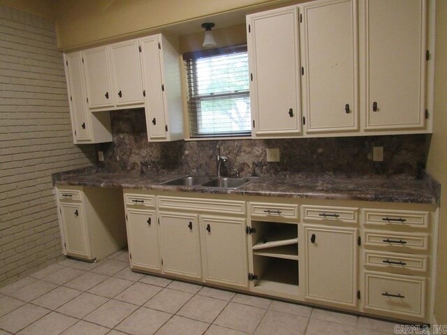 201 W Palm, Lonoke, AR 72086 - kitchen with a sink, tasteful backsplash, light tile patterned flooring, and brick wall