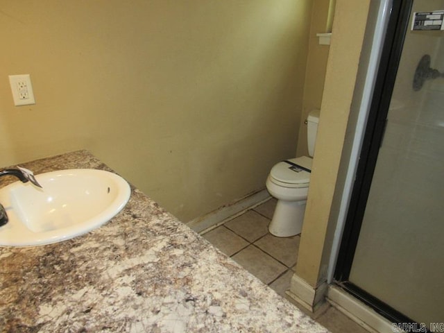 bathroom with an enclosed shower, tile patterned floors, sink, and toilet