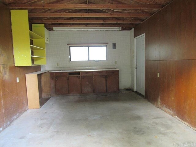 201 W Palm, Lonoke, AR 72086 - kitchen with light countertops, wood walls, and unfinished concrete flooring
