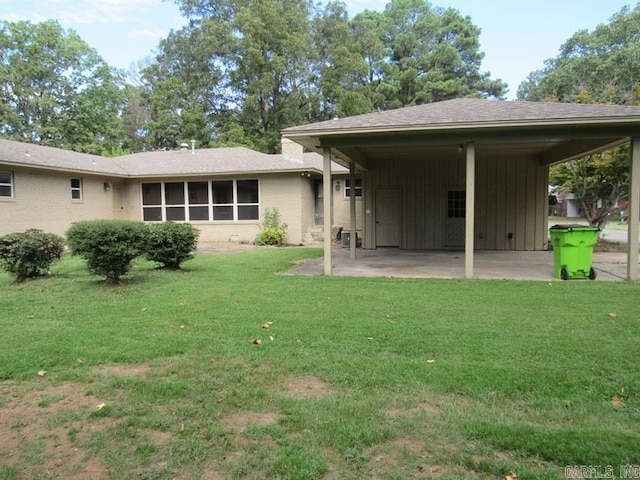 rear view of house featuring a yard and a carport