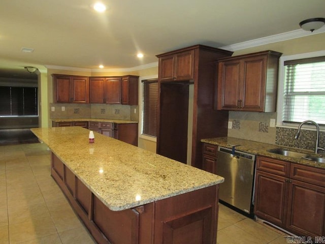 kitchen featuring ornamental molding, sink, a kitchen island, dishwasher, and light stone countertops