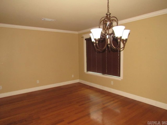 empty room featuring dark hardwood / wood-style floors, an inviting chandelier, and ornamental molding