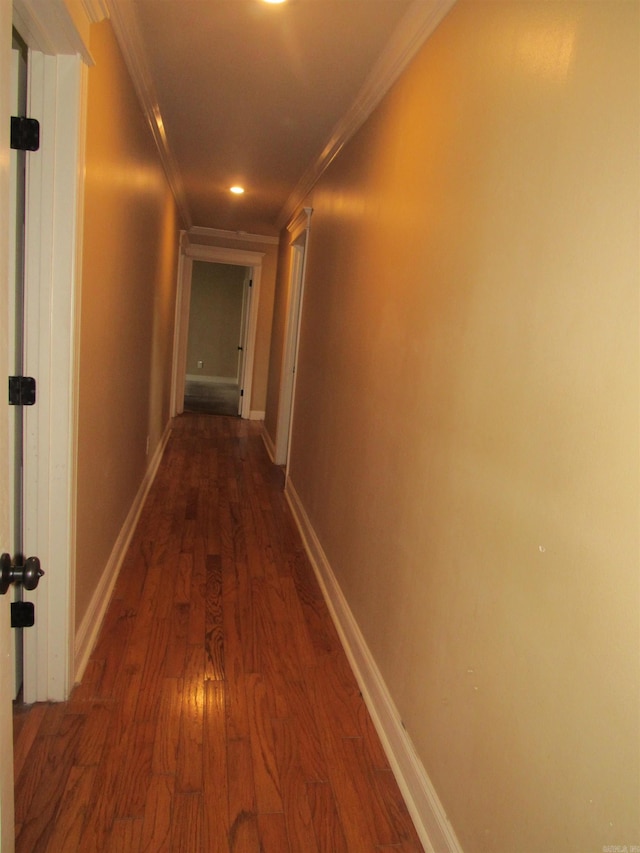 hallway with dark hardwood / wood-style floors and crown molding