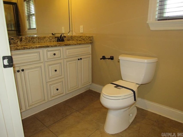 bathroom with tile patterned flooring, vanity, and toilet