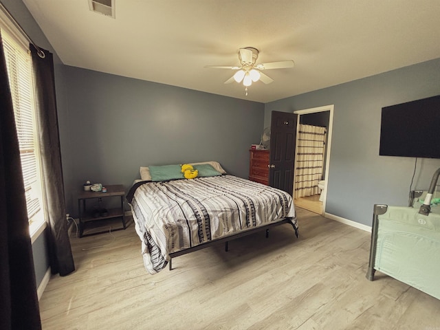 bedroom with ceiling fan, connected bathroom, and light hardwood / wood-style flooring