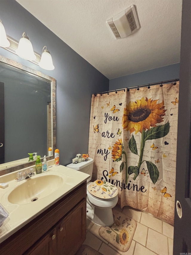 bathroom featuring a textured ceiling, tile patterned flooring, vanity, and toilet