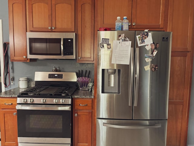 kitchen featuring dark stone countertops and appliances with stainless steel finishes