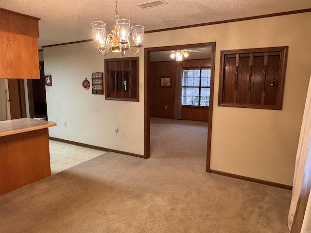 interior space with light colored carpet, a textured ceiling, and ornamental molding