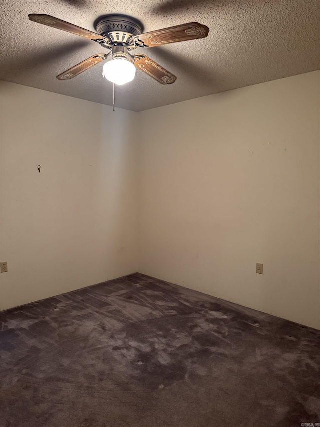 carpeted empty room featuring ceiling fan and a textured ceiling