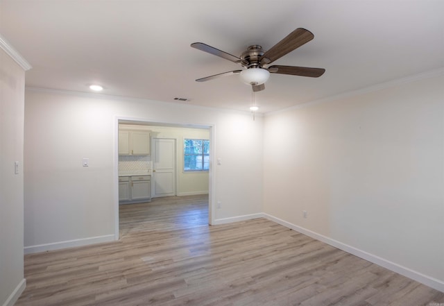 spare room featuring crown molding, light wood-type flooring, and ceiling fan