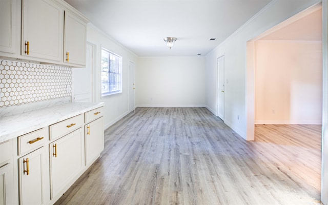 unfurnished dining area with crown molding and light hardwood / wood-style floors