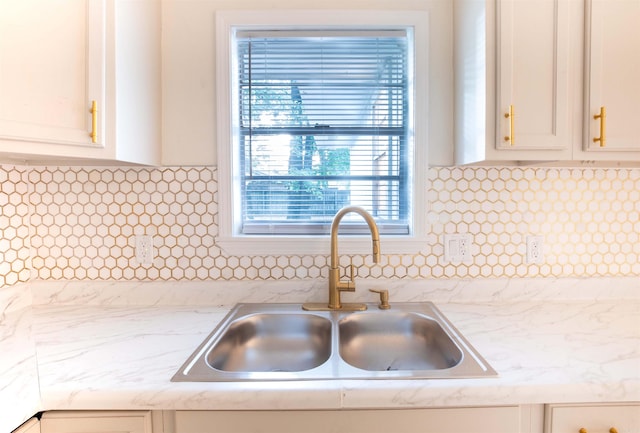 kitchen featuring white cabinets, sink, and tasteful backsplash